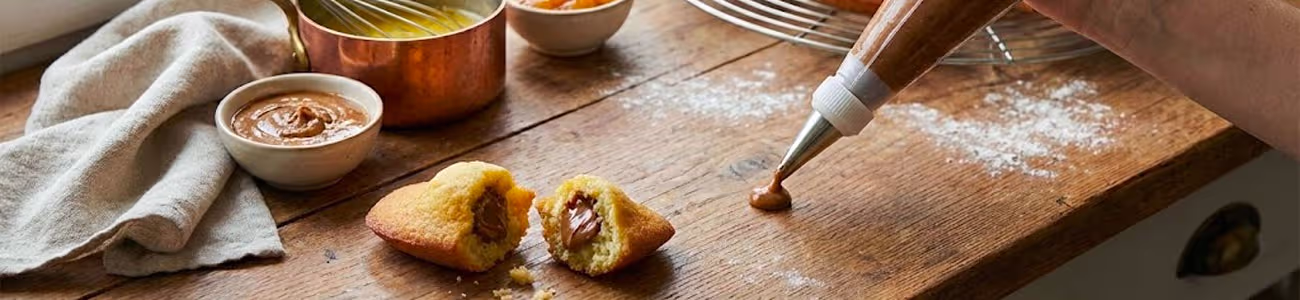 Madeleines dorées fourrées à la ganache au chocolat avec poche à douille