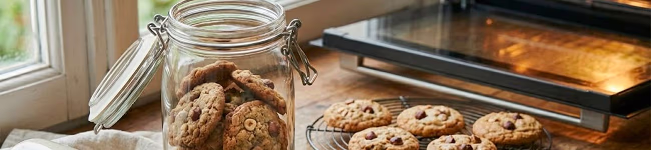 Biscuits secs : conserver le croquant et le récupérer s’ils ramollissent Biscuits secs croustillants et boîte métallique hermétique sur table en bois